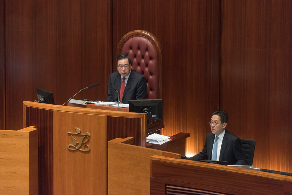 In a Legislative Council meeting, the Clerk to the Legislative Council sits on the left hand side of the President of the Legislative Council